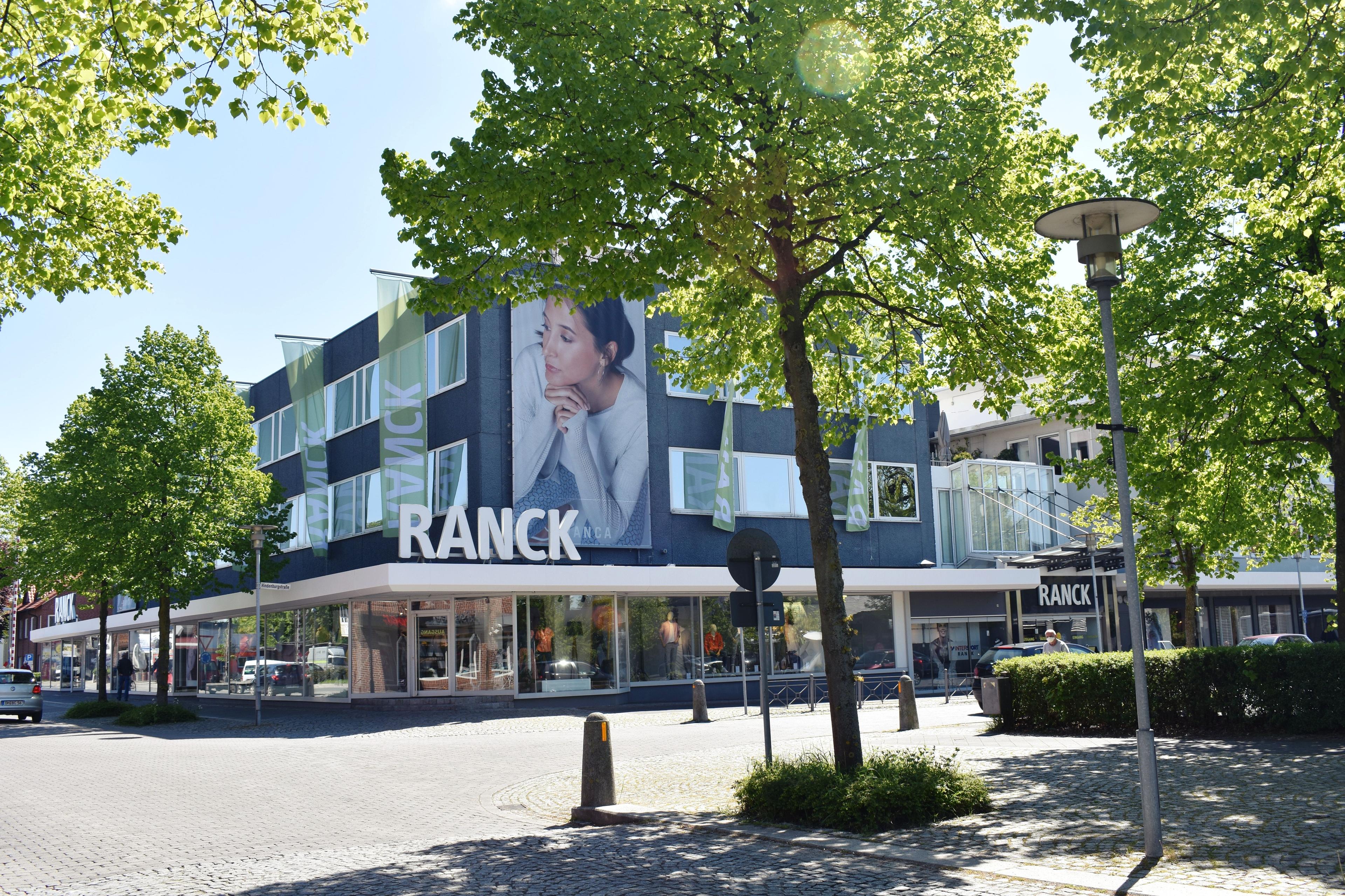 Modern building with a large 'RANCK' sign and a woman's advertisement on its facade.