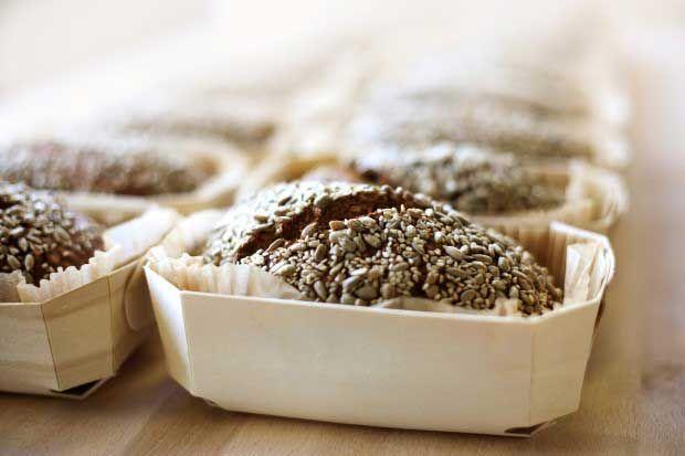 Small dark bread loaves with seeds, baked in individual wooden molds and dusted with flour.