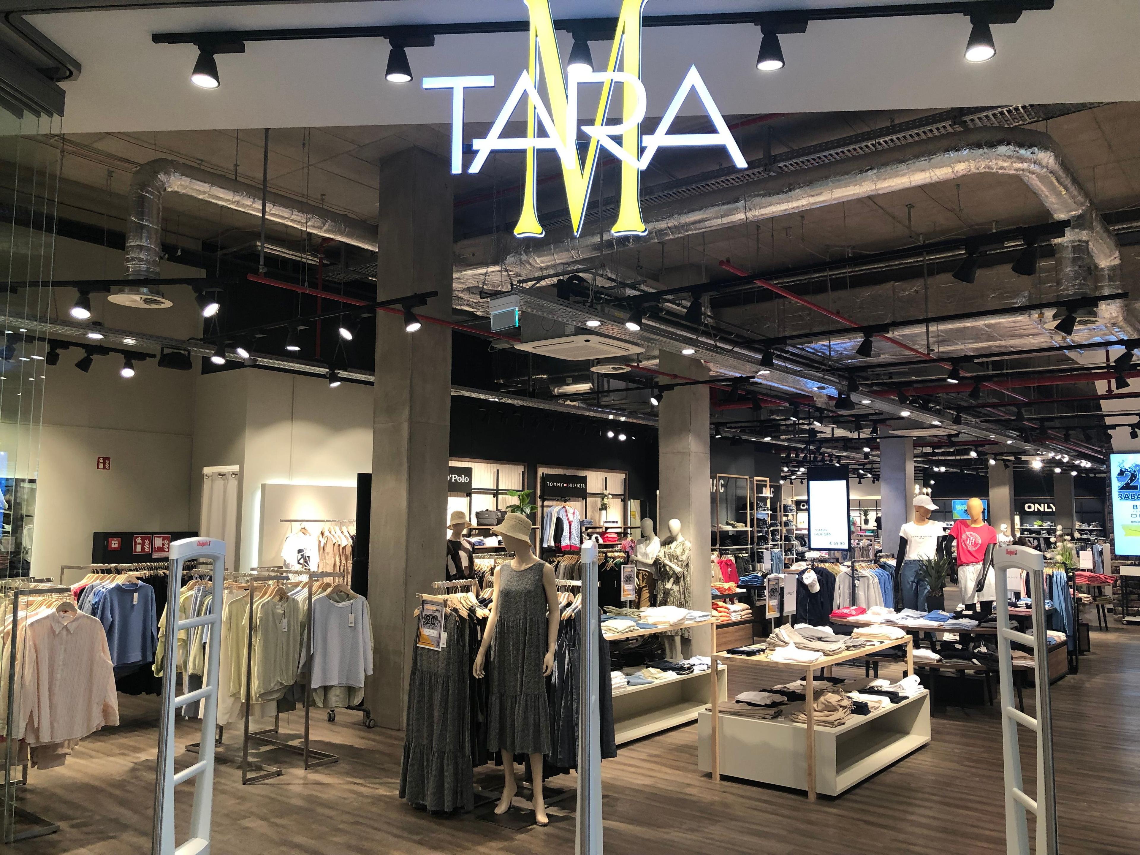 Entrance to a modern Tara clothing store with racks of apparel inside.